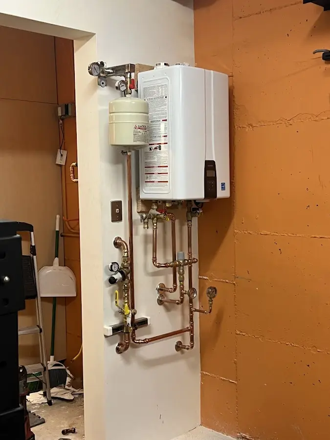 Plumbing technician inspecting water heater connections in Chesapeake Ranch Estates